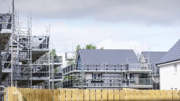 New houses under construction, covered in scaffolding