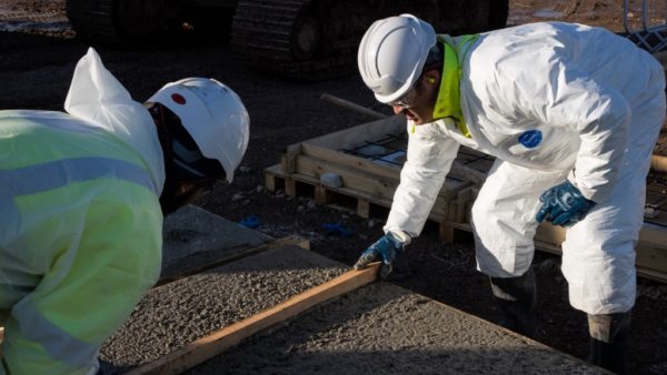 Workers lay the concrete slabs for the trial