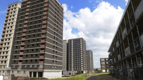 A row of high-rises against a blue sky with white clouds.