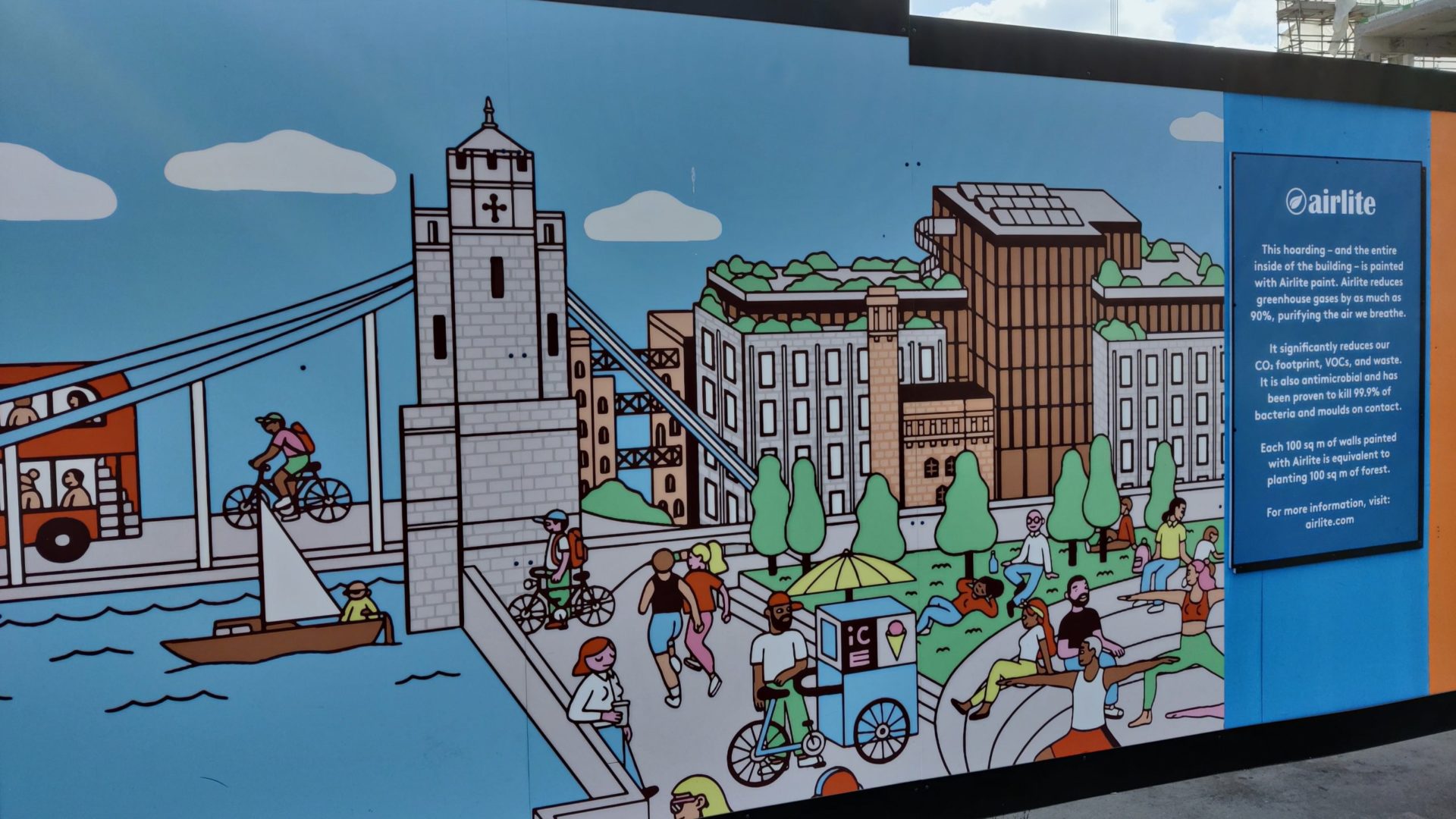 A hoarding with a painting of the Thames and Tower Bridge in London.