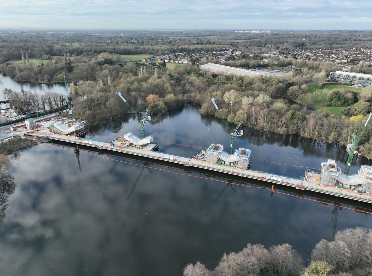 Aerial view of a lake and a bridge under construction.