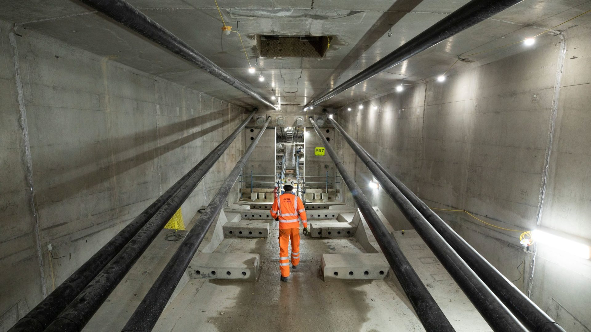 Colne Valley Viaduct A person in high-vis PPE walking inside a huge concrete tunnel.