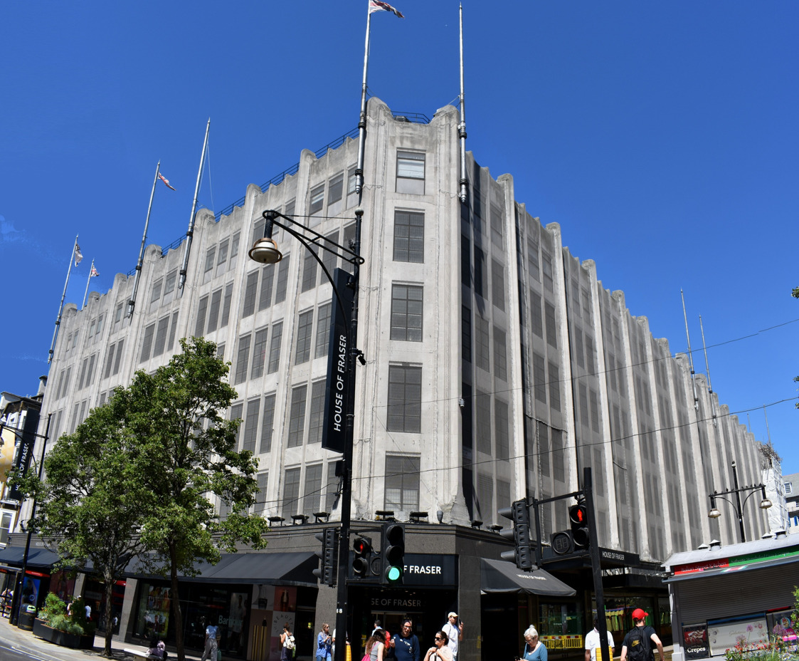 Street view of a big grey department store.