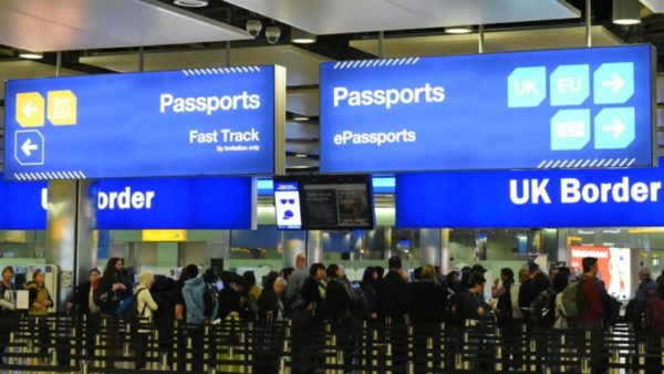 A long queue of people at the border of a UK airport.