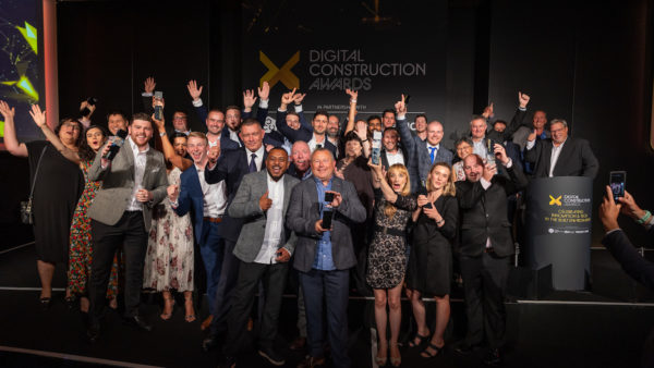A big group of happy people celebrating. Some have their hands up and some have trophies. Digital Construction Awards
