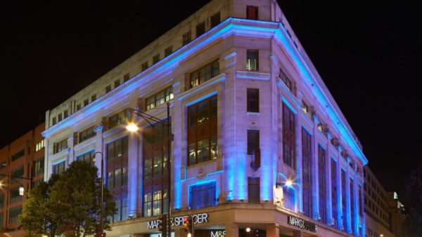 A big corner art deco building photographed at night