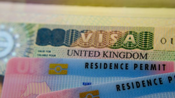 A UK visa document and two resident cards.