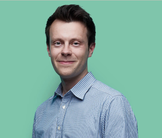 A man looking at the camera against a green background.