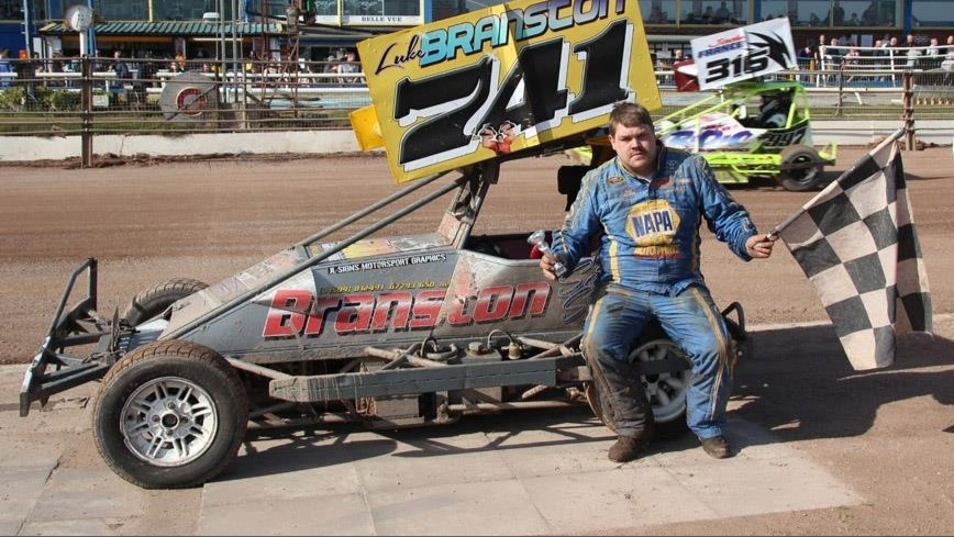 A man in front of a racing car.