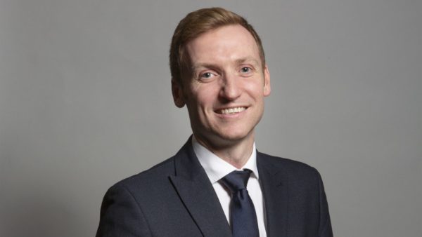 Mugshot of a man with tie smiling at the camera.