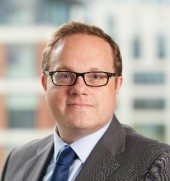 Mugshot of a man with glasses looking at the camera.