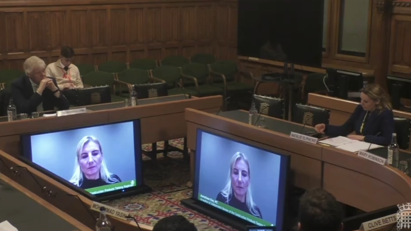 A room with a few people and two screens.