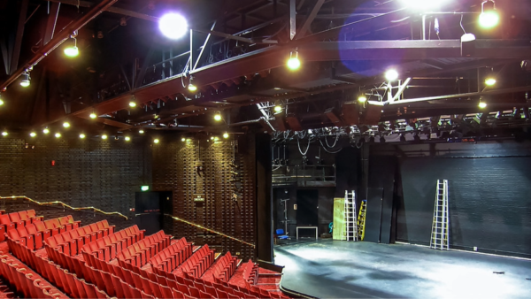 An empty theatre with red seats.