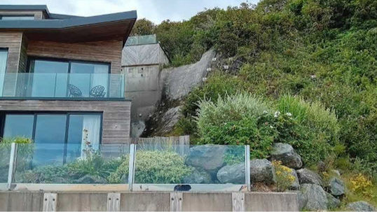 View of a terraced concrete building on a slope.