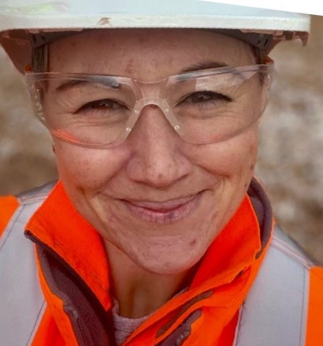 Mugshot of a woman with PPE smiling at the camera.