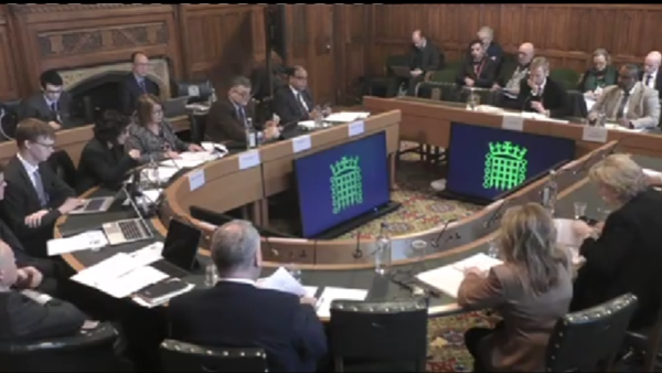 A formal setting with people around a table.