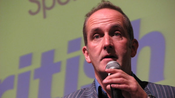 Mugshot of a man holding a microphone.