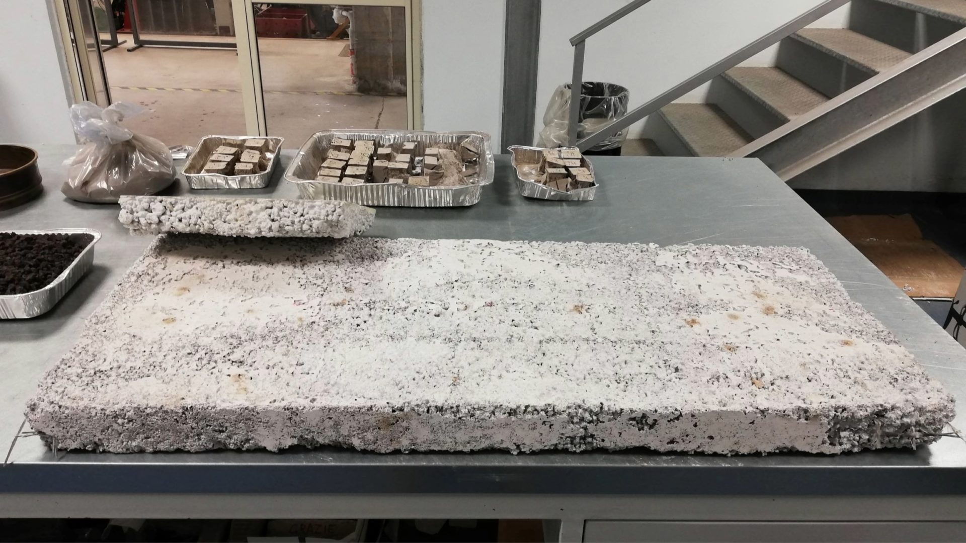 An insulating panel and tile with coarse ash