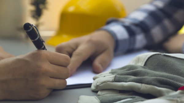 Two people signing a construction contract - JCT has released Design and Build 2024 contracts