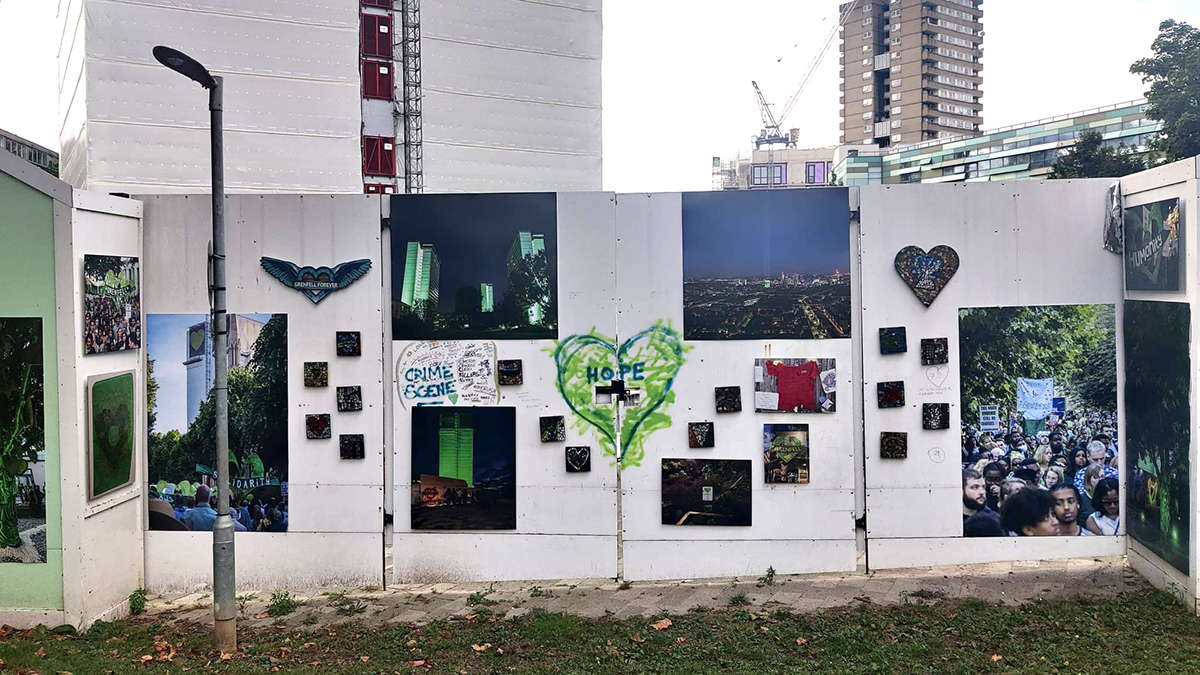 One of the white hoardings outside the Grenfell Tower with images that people have been posting and a green heart painted with the word 'hope' in it.
