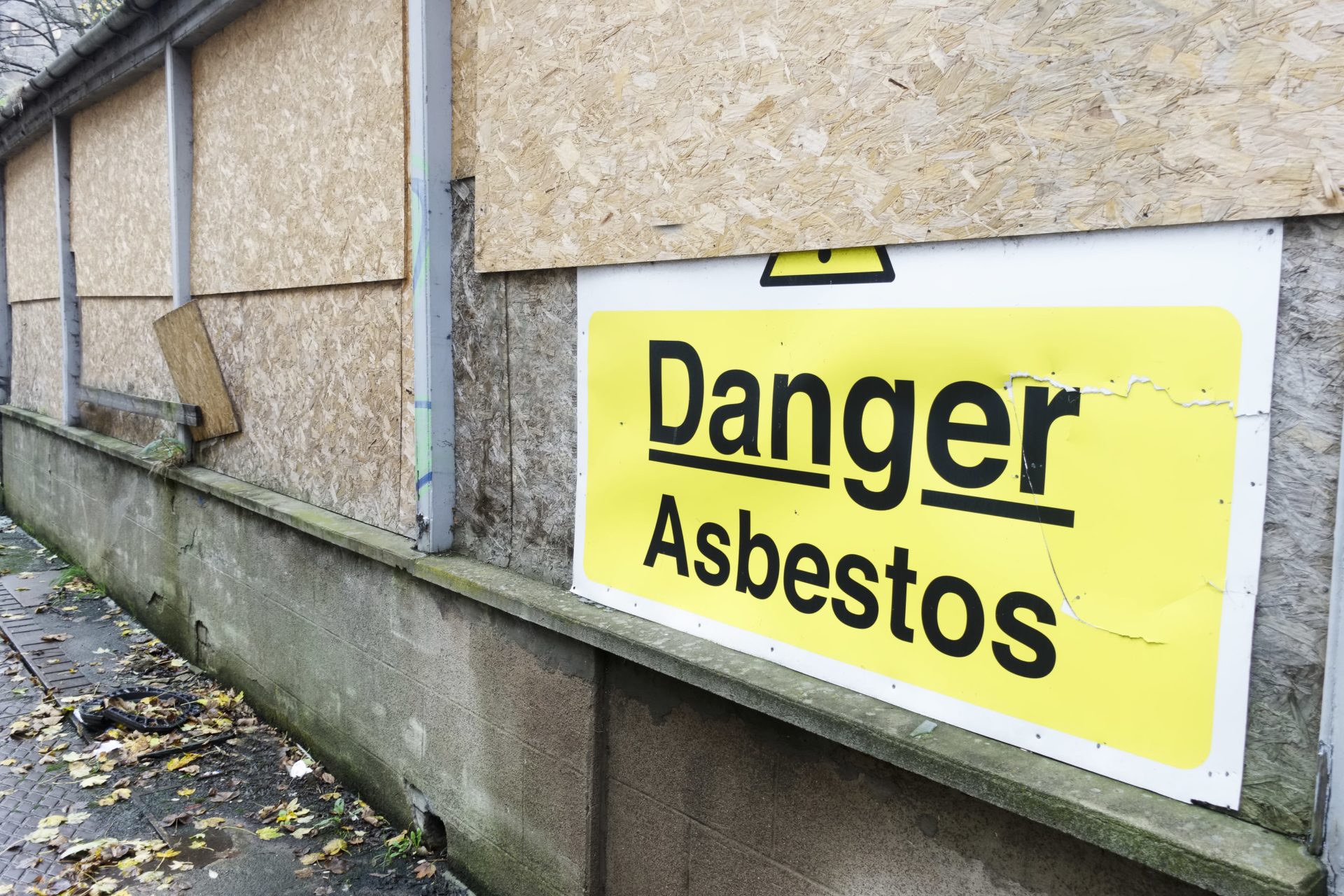 illegal asbestos removal - An asbestos danger sign at a building construction site - latest HSE data shows that the rate of work-related lung diseases is higher in construction
