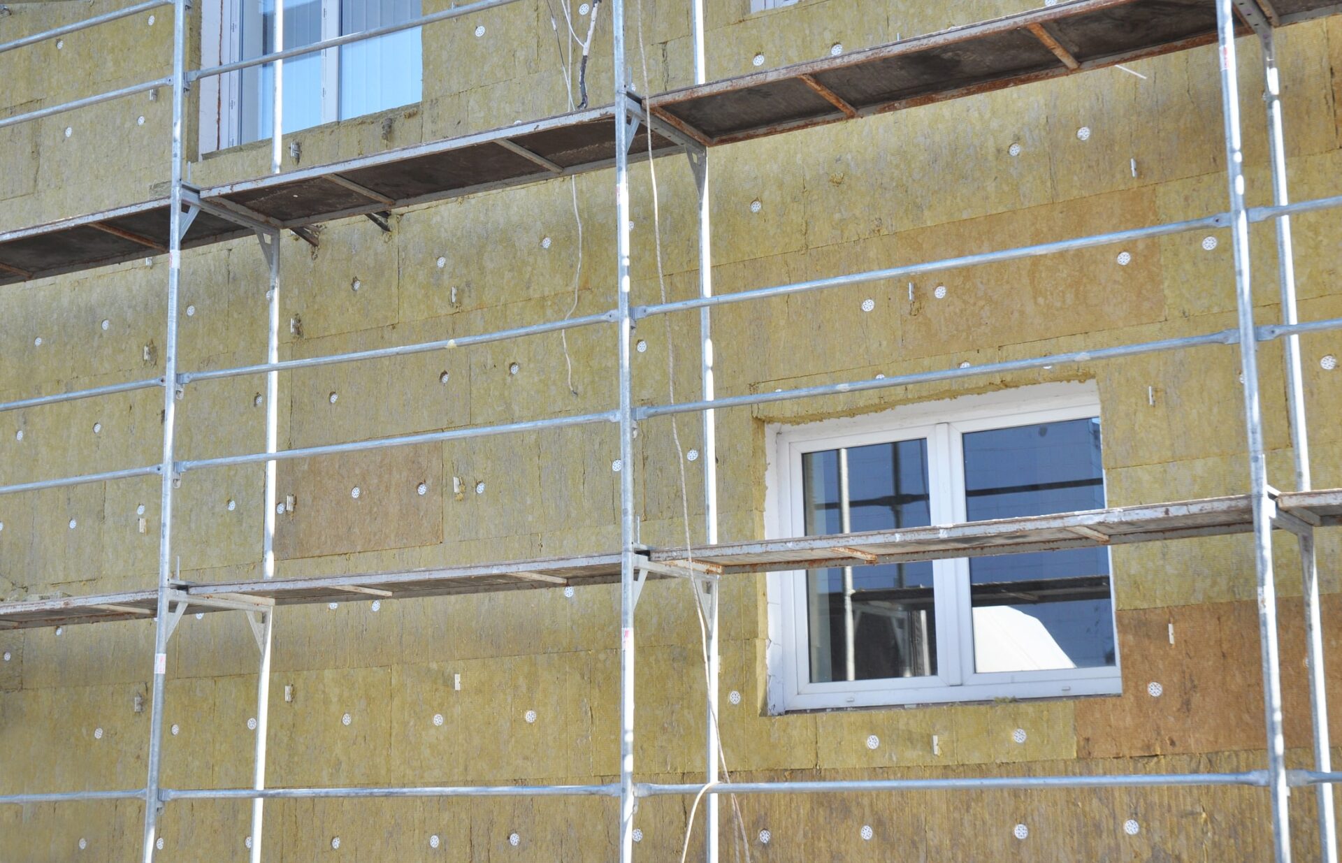 solid wall insulation - House facade renovation with mineral wool insulation boards outdoors - the government has suspended 39 businesses who installed poor-quality insulation.