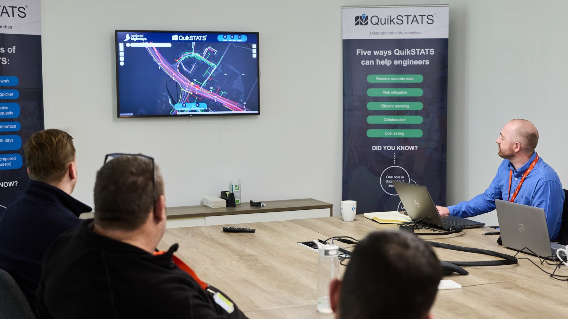 A big table with four men around it looking at a screen showing a digital map - QuikSTATS, part of the Kier Group, has been awarded a contract by National Highways to provide underground utility search data