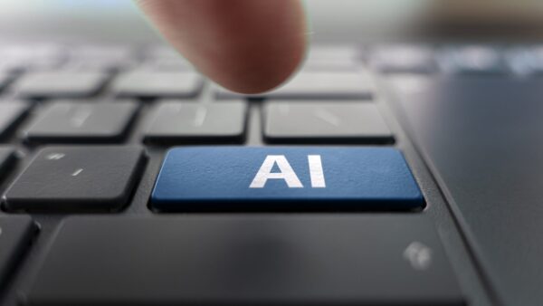 A person's hand pressing a key on a black computer keyboard that has an artificial intelligence key instead of enter. An accrediting body is warning businesses about using AI-generated technical advice.