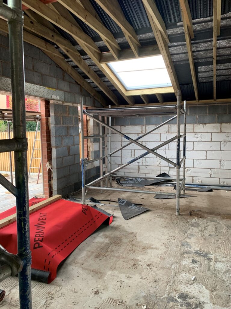 roof fall - A house extension under construction, there's a scaffold and a big area where a window will be installed - two companies have been fined after a worker fell through the window gap.