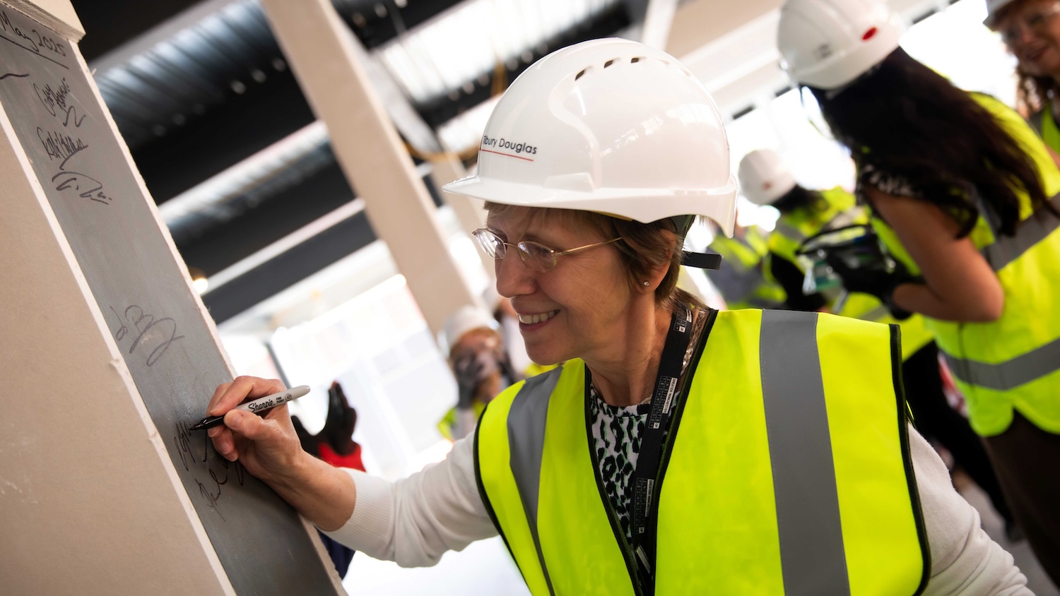Director Claire Foreman signs the steel post in the new GMIoT building (image: University of Salford/GMIoT)