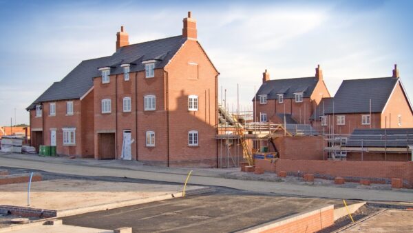 New homes in the process of being built with foundations in the foreground set against a blue sky - research by the Home Builders Federation show that Section 106 agreements add 16 months to the planning process