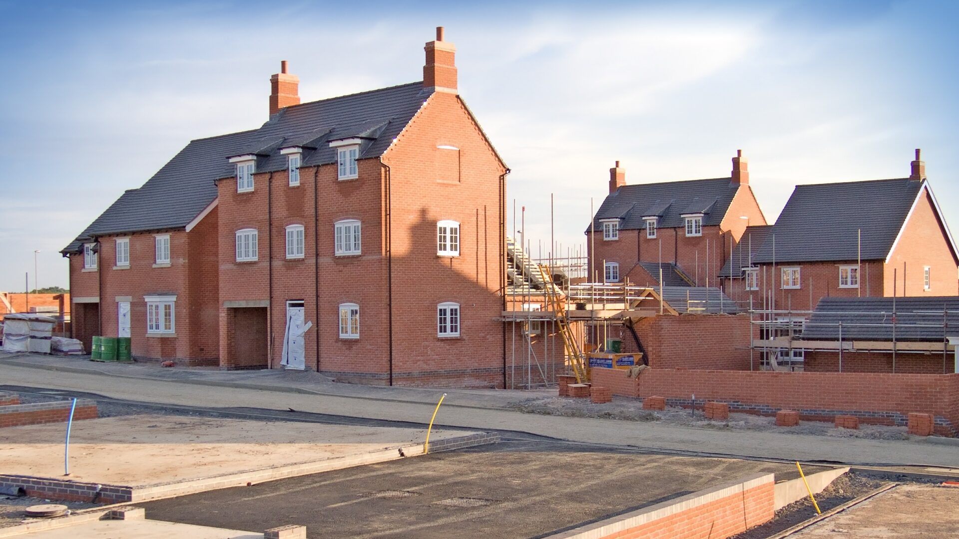 S106 - New homes in the process of being built with foundations in the foreground set against a blue sky - research by the Home Builders Federation show that Section 106 agreements add 16 months to the planning process