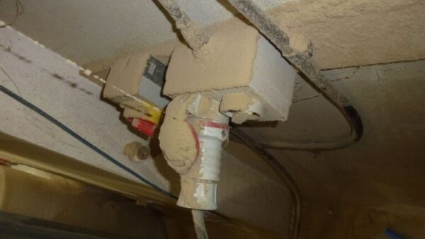 A socket covered in dust - a joinery has been fined after a surprise visit identified various failings.
