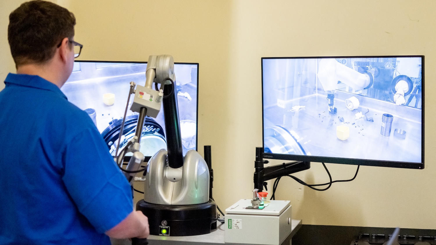 An operator using remote control to control a robotic arm in a nuclear glovebox in the Sellafield facility
