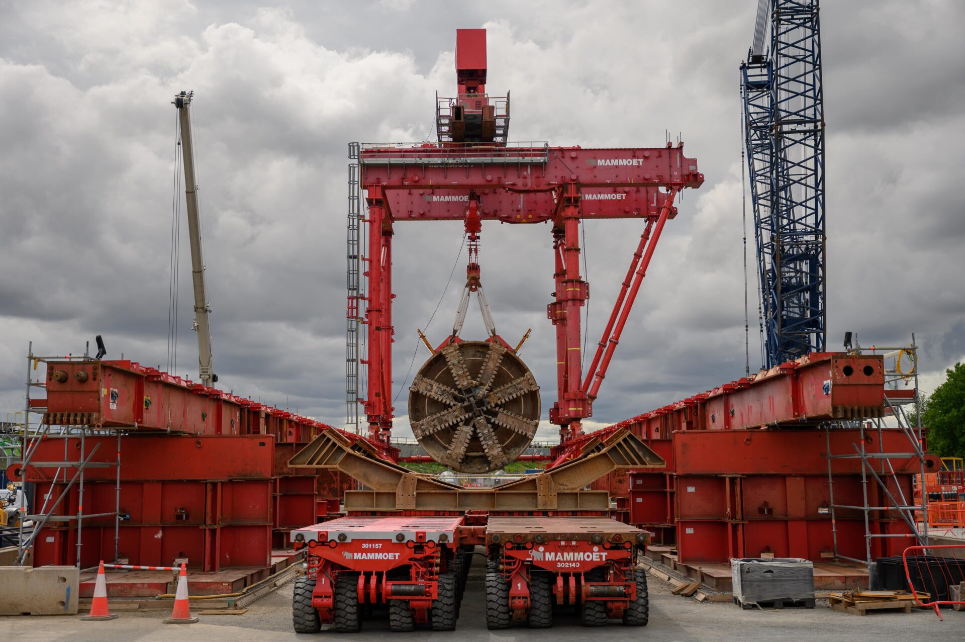 A giant boring tunnel machine being lifted from a shaft using a gantry crane