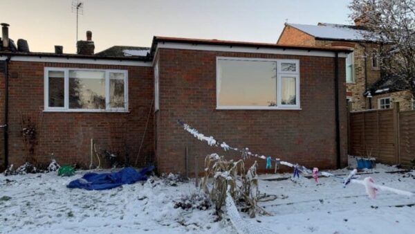 A house with a flat roof surrounded by snow - a roofer has been fined after failing to provide edge protection that led to serious injury