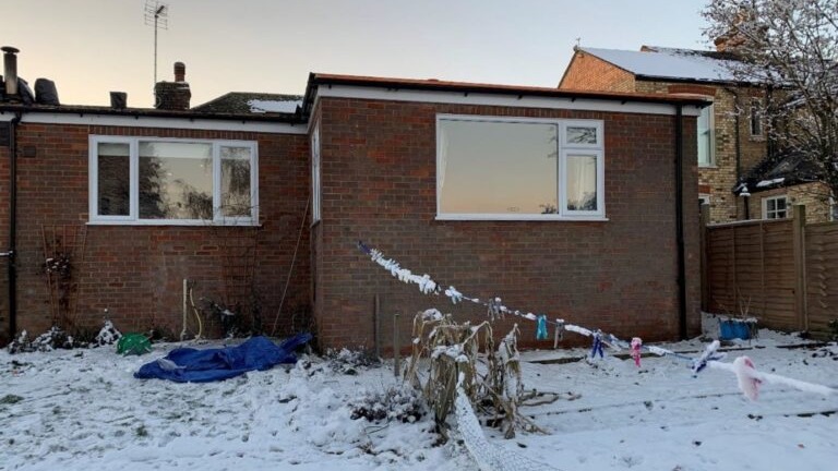 A house with a flat roof surrounded by snow - a roofer has been fined after failing to provide edge protection that led to serious injury