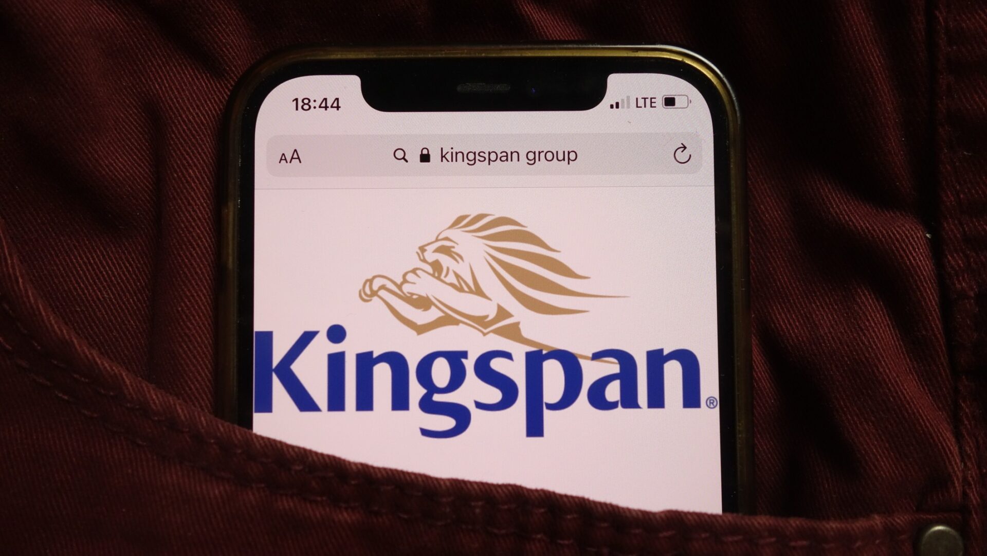 Kingspan Group plc logo displayed on mobile phone hidden in jeans pocket - The Competition and Markets Authority has cleared Kingspan's acquisition of Coverworld.
