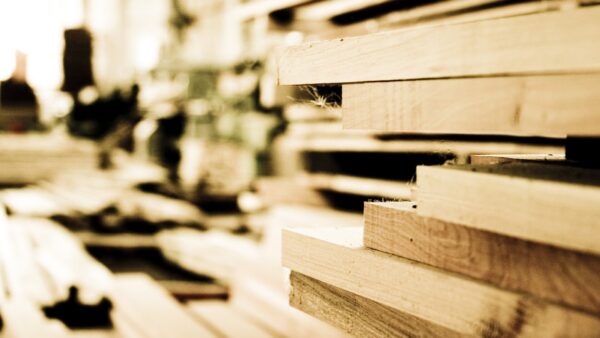 Stacks of wood building planks in a warehouse - CIOB has published a new guide about construction products